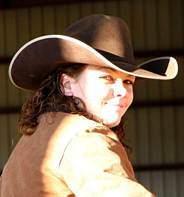 Young woman smiling wearing a cowboy hat
