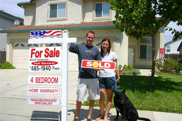 Photo of 1 of our Sellers with a Sold sign in front of their home.